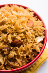 Traditional Jaggery Rice or Gur wale chawal in Hindi, served in a bowl with spoon. selective focus
