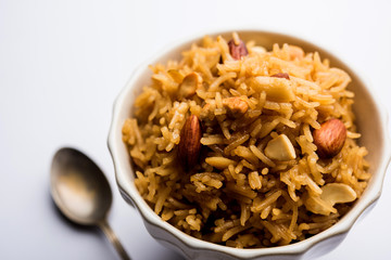 Traditional Jaggery Rice or Gur wale chawal in Hindi, served in a bowl with spoon. selective focus
