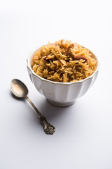 Traditional Jaggery Rice or Gur wale chawal in Hindi, served in a bowl with spoon. selective focus