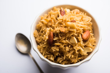 Traditional Jaggery Rice or Gur wale chawal in Hindi, served in a bowl with spoon. selective focus