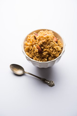 Traditional Jaggery Rice or Gur wale chawal in Hindi, served in a bowl with spoon. selective focus