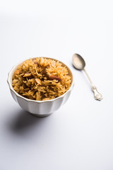 Traditional Jaggery Rice or Gur wale chawal in Hindi, served in a bowl with spoon. selective focus