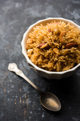 Traditional Jaggery Rice or Gur wale chawal in Hindi, served in a bowl with spoon. selective focus