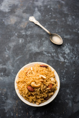 Traditional Jaggery Rice or Gur wale chawal in Hindi, served in a bowl with spoon. selective focus