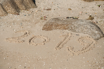 closeup of 2019 writing in the sand on the beach