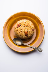 Traditional Jaggery Rice or Gur wale chawal in Hindi, served in a bowl with spoon. selective focus