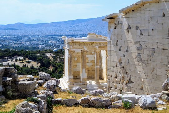 A view of the Temple of Athena Nike , which is a temple on the Acropolis of Athens, dedicated to the goddess Athena Nike.  The city of Athens is in the background