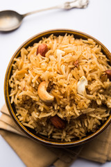 Traditional Jaggery Rice or Gur wale chawal in Hindi, served in a bowl with spoon. selective focus