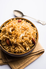 Traditional Jaggery Rice or Gur wale chawal in Hindi, served in a bowl with spoon. selective focus