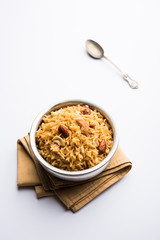 Traditional Jaggery Rice or Gur wale chawal in Hindi, served in a bowl with spoon. selective focus