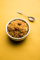 Traditional Jaggery Rice or Gur wale chawal in Hindi, served in a bowl with spoon. selective focus