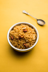 Traditional Jaggery Rice or Gur wale chawal in Hindi, served in a bowl with spoon. selective focus