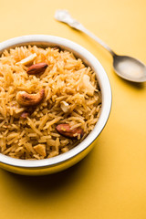 Traditional Jaggery Rice or Gur wale chawal in Hindi, served in a bowl with spoon. selective focus