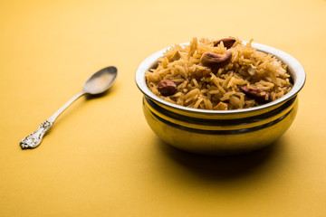 Traditional Jaggery Rice or Gur wale chawal in Hindi, served in a bowl with spoon. selective focus
