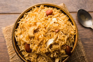 Traditional Jaggery Rice or Gur wale chawal in Hindi, served in a bowl with spoon. selective focus
