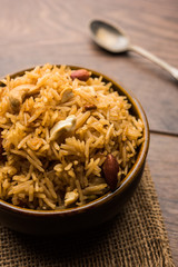 Traditional Jaggery Rice or Gur wale chawal in Hindi, served in a bowl with spoon. selective focus
