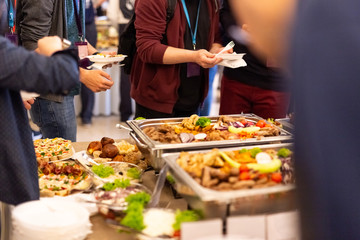 Obraz premium Close up of people serving themselves with canapes in buffet of restaurant.