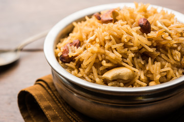Traditional Jaggery Rice or Gur wale chawal in Hindi, served in a bowl with spoon. selective focus