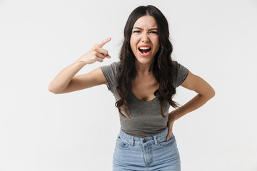 Beautiful displeased screaming young woman posing isolated over white wall background.