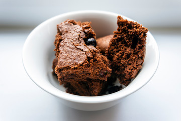 chocolate brownies with fresh berries and chocolate background, side view
