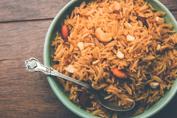 Traditional Jaggery Rice or Gur wale chawal in Hindi, served in a bowl with spoon. selective focus