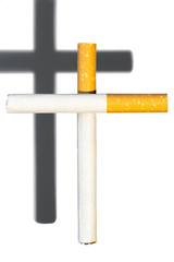 Close up of two cigarettes throwing a cross shadow