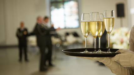 A tray with three glasses of champagne. Waiter holding a tray with a champagne glass