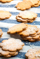 Stack freshly baked flat cookies on a blue striped tablecloth