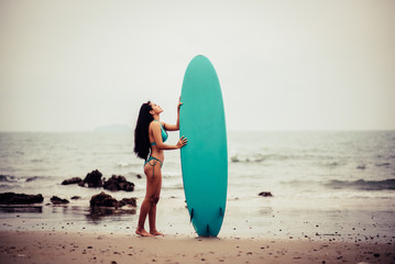 Beautiful asian sexy woman with surfboard on the beach.