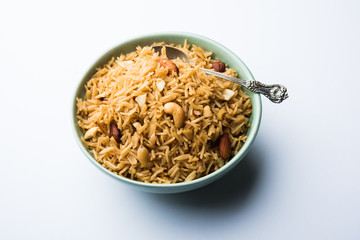 Traditional Jaggery Rice or Gur wale chawal in Hindi, served in a bowl with spoon. selective focus