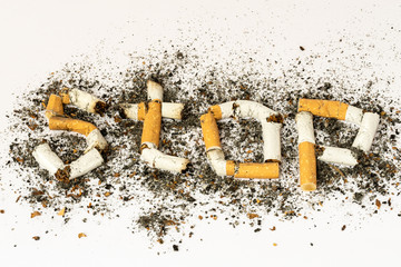 The letters S T O P made from cigarette butts surrounded with ash