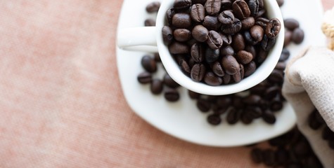 Cup filled with coffee beans.