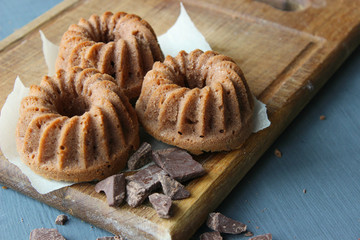 Muffins sprinkled with powdered sugar on a wooden background. Homemade cake. Sweet home-made dessert. Copy space.