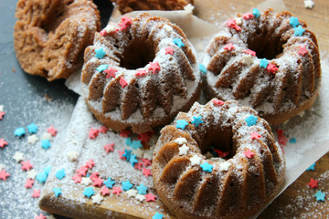 Muffins sprinkled with powdered sugar on a wooden background. Homemade cake. Sweet home-made dessert. Copy space.