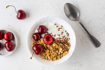 Healthy breakfast with greek yogurt, granola (muesli), flax seeds, cherries. Health care, fitness, diet concept.