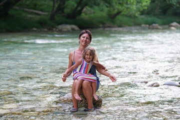 Mother and daughter enjoy the view of the Acheron river with its pristine nature in Epirus, Greece