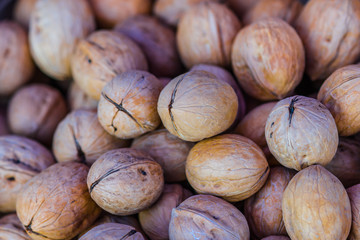 Closeup view of walnuts in a pile on display for sale. Healthy natural food