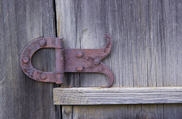 forged rusty hinge on wooden door