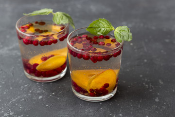 Fresh cool detox drink with berries and peaches or aprikotes.