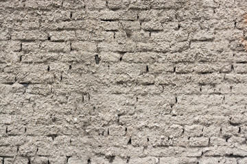 Grey stucco grungy wall surface covering brick tile pattern