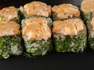 sushi rolls on gray stone slate on wood background
