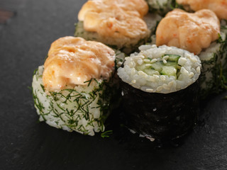 sushi rolls on gray stone slate on wood background