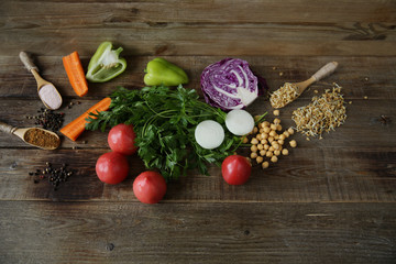 Top view. Flat lay. Organic Healthy Food, Fresh vegetables, greens, germinated legumes, spices on a wooden table. The concept of healthy eating. Ingredients for cooking. With copy space for text.
