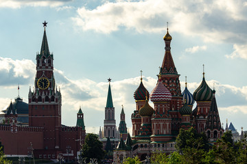 Naklejka premium View oна Spas Tower of Moscow Kremlin and St. Basil's Cathedral from of Zaryadye Park against blue sky. People stand on observation deck of building and take pictures. Moscow, Russia June, 2019