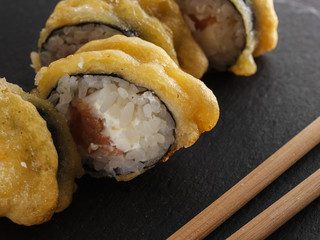 sushi rolls on gray stone slate on wood background