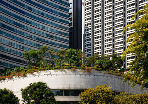 Modern glass buildings with garden and trees on roof in Singapore