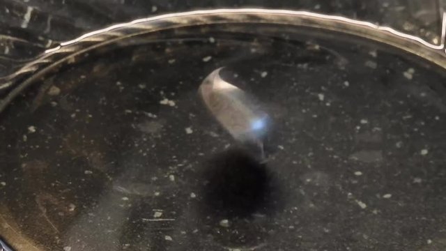 4K footage 30fps. 2 euro coin stand up and start twisted asa crazy on a glass plate. Loop 17 seconds 4K macro video with zoom-out and zoom-in effects.