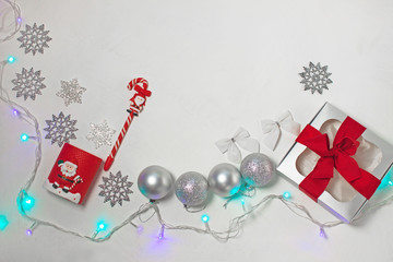 Christmas composition of red and silver decorations, gift box with ribbon bow, flatlay.