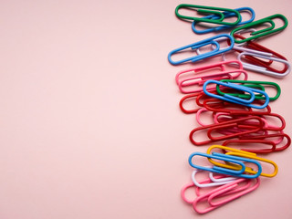 multicolored paper clips on a pink background. The concept is time to school.