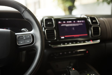 Obraz na płótnie Canvas selective focus of steering wheel near gear shift handle in luxury car